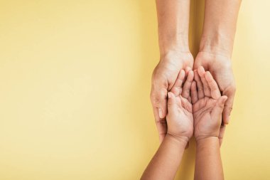 Stüdyo görüntüsü, aile bireylerinin kapalı arka plan görüntüsü. Ebeveynler ve çocuklar boş alanı bir arada tutarak sevgi ve desteği sembolize ediyorlar. Aile ve Veli Günü konsepti.