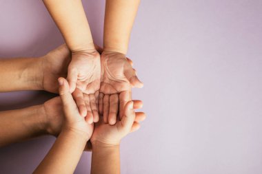 Aile Günü 'nü kutluyoruz, ailelerin ve çocukların renkli arka planda el ele tutuşmalarını izliyoruz. Birlikteliğin ve nesiller arası bağlantının sembolü.