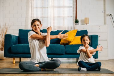 Bir anne ve kızı spor salonunda uyumlu bir aile ortamı yaratıyor. Gerinme ve yogayla meşgul oluyorlar. Birlikteliği destekliyorlar..