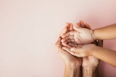 Ebeveyn ve çocuğun renkli bir arka planda el ele tutuşması. Aile Günü birliktelik ve desteği kutluyor..