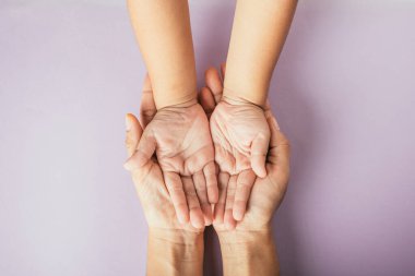 Aile gününü kutluyoruz, aile ve çocuğun renkli bir arkaplanda el ele tutuşmasını izliyoruz. Metin için boşluk.