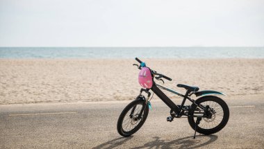 Soyut güzellik sahil neşesiyle buluşur, plajda bisiklet, yaz günü özgürlüğü ve rahatlamayı sembolize eder ve su dalgalarının yanında eşsiz bir turizm deneyimi yaratır. Yaz tatillerinde bisiklet