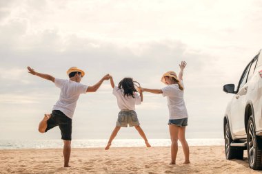 Mutlu aile üç el ele verip kumsalda zıplar, anne ve babalar çocuklarının arabasına atlayıp, yaz tatiline çıkarlar, yaz gezisine çıkarlar, aile günlerini birlikte geçirirler.