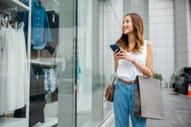 Dışarıda yürüyen genç bir kız, gözleri akıllı telefon ekranına yapışmış. Bildirimler ve uygulamalar dünyasında kayboldu, modern iletişimin sanal gerçekliğiyle bağlantılı..