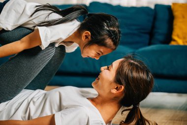 Evlerinde bir anne ve çocuğu, pilates yaparken uçak gibi uçar gibi davranarak ve yoga yaparak aralarındaki bağı güçlendirerek ve mutluluğu paylaşarak aile fitnesinin eğlencesini kucaklıyor..