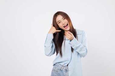 Kadın jestleri bana işaret dili ile işaret ediyor, başka bir kadın da telefonu parmaklarıyla ve işaret parmağıyla taklit ediyor, hem neşeli hem de ifade edici, beyaz arka planda izole edilmiş..