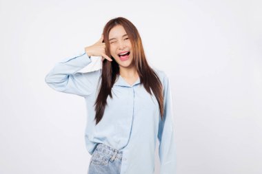 Kadın bana parmaklarıyla jest yaptırıyor, başka bir kadın göz kırparken telefon taklidi yapıyor, beyaz arka planda neşeli bir stüdyo pozu veriyor..