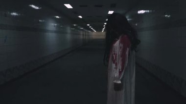 Bloody halloween makeup. Asian woman zombie with blood she death and scary at dark night in tunnel, Horror bloodthirsty ghost girl hair covering face and eye reach arm out, Happy halloween day concept