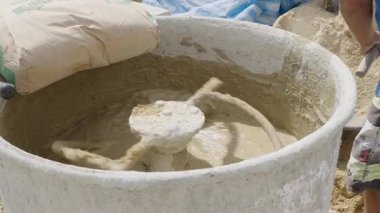 İnşaat tipi beton karışımı: Çimento karıştırıcı gri harç ve bronz kumu kullanıma hazır bir karışıma dönüştürüyor.