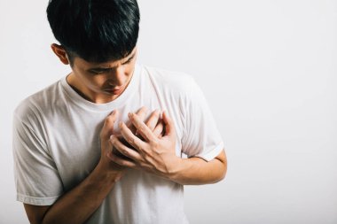 Kollarını göğsüne dolayan Asyalı genç adam kalp krizi stüdyosunun izole ettiği beyaz arka plan, mutlu yaşam tarzı erkeklerin göğüs ağrısı kalp rahatsızlığı sorunları yüzünden acı çekiyor.