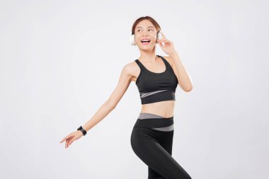 Dans, aktif kalırken çalma listesini dinlerken enerjisini arttırıyor. Her atışında, vücudu tepki veriyor ve tekrar neşe ve dikkatle dans etmeye başlıyor. izole stüdyo beyaz arkaplan