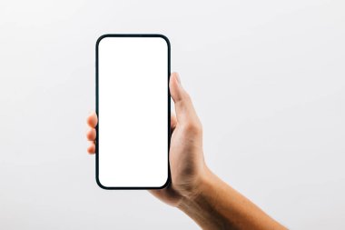 Beyaz arka planda izole edilmiş siyah bir cep telefonu tutan bir el, siyah akıllı telefon tutan bir adam boş ekran görüntüsü, web sitesi tasarım uygulaması