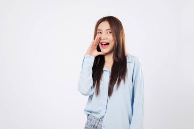 Başka bir kadın yüksek sesle bir duyuru yaparken, başka bir kadın ellerini dudaklarına koyuyor. Gözleri neşe içinde, beyaz bir arka planda izole edilmiş şaşkınlık ve heyecanı ifade ediyor..