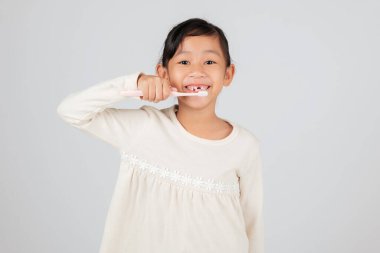 Diş fırçası ve diş aralığı olan gülümseyen bir çocuk. Diş hekimi diş dökülmesi ve ağız bakımı üzerine eğitim veriyor ve günlük hijyeni çocukların rutininin önemli bir parçası haline getiriyor. izole edilmiş beyaz arkaplan