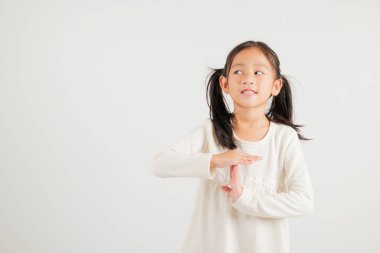 Yakından bakınca gülümseyen genç kız el hareketi yapıyor. Stüdyo çekimleri beyaz arka planda. Anaokulu çocuğu el işaretini kırıyor, zamanı fotokopi ile durduruyor.