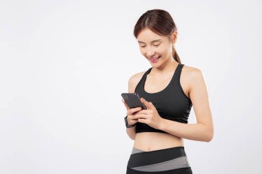 Telefonu hazır ve telefonu bir uygulama için açıkken, bu güçlü kadın spor kıyafetlerine, spor hayatına ve modern mobil teknolojiye güvenle gülümsüyor. izole stüdyo beyaz arkaplan