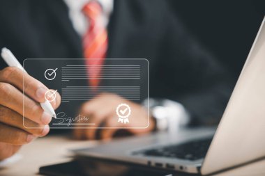 Kusursuz teknoloji entegrasyonu İşadamı elektronik belgeleri sanal ekranda kalemle imzalıyor. Elektronik imza kavramını ve etkin çevrimiçi belge yönetimini gösterir.
