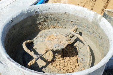 Gri harç ve kumla doldurulmuş çimento karıştırıcısı. İnşaata hazır beton karışımı yaratmak için çalkalanan bıçaklar..