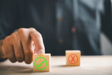 İşadamının parmağı, tahta küplere dokunarak doğru ve yanlış seçimleri gösteren işaretler çizer. Karar verme mekanizmasında seçim onayını iletir. Evet ya da Hayır ile Düşün.