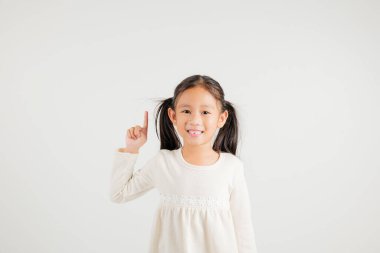 Asyalı mutlu bir portre. Sevimli bir kız el hareketi yapıp ürününü sunuyor. Stüdyo resmi, beyaz arka planda izole edilmiş, kreş çocuğu kadın gülümsemesi.