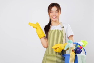 Elinde bir kova tutarken temizlik malzemeleri hazır ve avucuyla el kol hareketi yapıyor. Temizlik yeteneği her eve ışıltı ve ışıltı getiriyor. Metnin için izole edilmiş stüdyo beyaz arkaplan alanı