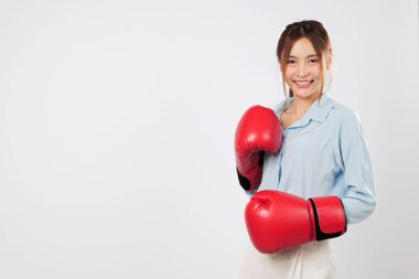 Kırmızı boks eldivenli, gülümseyen Asyalı genç bir kadının boks duruşu. Formda ve kendinden emin bir boksör güçlü bir dövüş enerjisi gösteriyor. izole stüdyo beyaz arkaplan