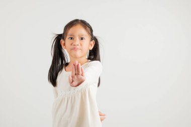 Asya portresi gülümseyen küçük kız dur işareti yapıyor avuç içi dolu ama mutsuz yüz stüdyosu çekimleri beyaz arka planda, anaokulu çocuklarının kopya alanı şüphesiyle izole edilmiş