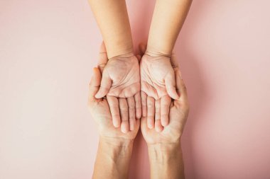 Ebeveynler ve çocuklar el ele tutuşuyorlar. Renkli arka planda soyutlanmışlar. Aile Günü birliktelik ve desteği kutluyor..
