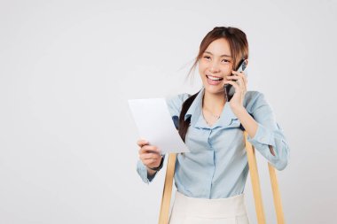 Koltuk değnekleriyle ayağı kırılan mutlu bir kadın elinde fatura kağıtlarıyla sigorta şirketini arıyor. Sigorta acentesiyle konuşmak ona iyileşme ve maliyet sigortası konusunda huzur veriyor. izole stüdyo beyaz arkaplan