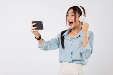 Kazanan duygu yüzünü aydınlatır. Kulaklık takan kadın oyun oynarken heyecanlanır, kutlamak için elini kaldırır ve bir sonraki mobil galibiyetten sonra neşeyle güler. Çevrimiçi izole edilmiş beyaz arka plan videosu izleriz.