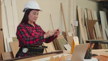 Kırmızı ekose gömlekli bir kadın ahşap atölyesinde bıçakla kalem kesiyor. Marangozluk, DIY projeleri ve işçilik üzerine odaklı afişler için ideal, Carpenter