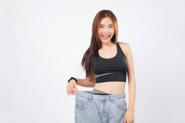 Bu sıska kadın gururla gülümserken, büyük beden kotlar kilo kaybının altını çiziyor. Daha sonra, dönüşümünden çok etkilenmiş bir çift daha tutuyor. izole stüdyo beyaz arkaplan