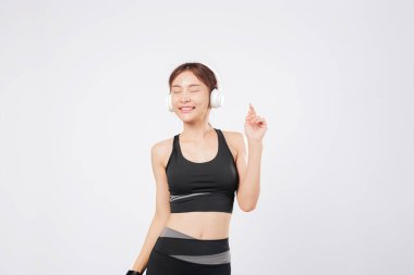 O kulaklıklarla eğlenirken dans onun yerini alıyor. Daha sonra, vücudu yeniden yeni bir ritme kapılır ve günlük neşesinin bir parçası olarak dansı kucaklar. izole stüdyo beyaz arkaplan