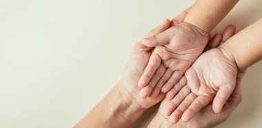 Aile Günü konsepti, ebeveyn ve çocuğun el ele tutuşması. Birlikteliğin desteğini ve mirasın nesilden nesile geçtiğini gösteriyor..