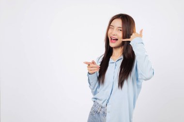 Bana işaret veren bir kadın, parmaklarını telefon gibi kullanır ve işaret eder, ikinci kadın gülümser ve eli kulağının dibinde, beyaz arka planda izole bir şekilde poz verir..