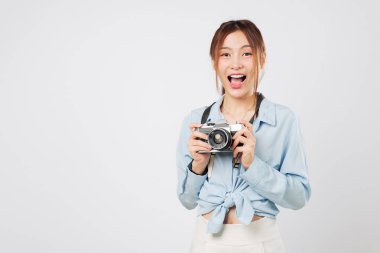 Kamerayla gülümseyen Asyalı turist, tatile hazır turist. Mutlu genç Asyalı gezgin elinde fotoğraf makinesiyle yaz tatilinin tadını çıkarıyor. izole stüdyo beyaz arkaplan