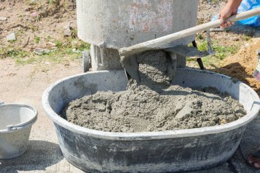 Gri harç ve bronz kum karışımı bir çimento karıştırıcı, inşaat kullanımı için mükemmel tutarlılık yaratır.