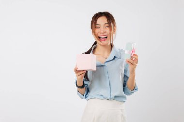 Özel bir günü kutlayan Asyalı bir kadının parlak bir gülümsemesiyle açılan hediye kutusu sevdiği birinden başka bir pembe hediye almanın verdiği heyecanın tadını çıkarıyor. izole stüdyo beyaz arkaplan