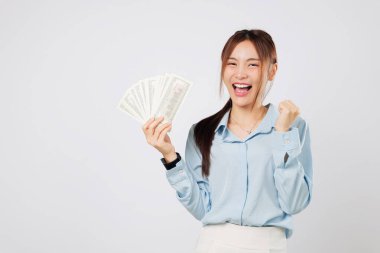 Mutlu kadın yumruğunu kaldırarak alkışlıyor, hayran banknotları tutuyor, şanslı anı kutluyor ve para ve başarıyla güçlendiğini hissediyor. izole stüdyo beyaz arkaplan