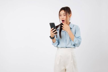 Asyalı kadın telefon şoku. Üzücü sürpriz. Kapalı ağızlı, şok olmuş, cep telefonundan kötü haberler okuyor.