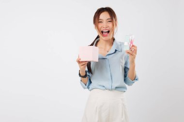 Heyecanlı bir kadın tarafından iki eliyle tutulan bir hediye büyük bir gülümsemeyle açarken, içinde özel bir şey ve yanında başka bir pembe hediye gördüğüne şaşırdı. izole stüdyo beyaz arkaplan