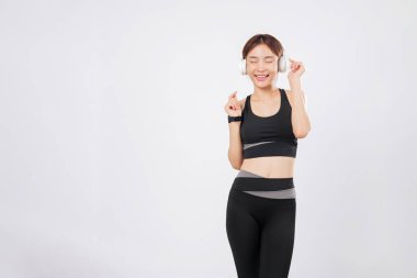 Dans, spor kulaklıklarıyla yaptığı her antrenmanın en sevdiği kısmıdır. Ritmi düşerken, dans etmekten kendini alamıyor, müzik ve zindelik enerjisiyle parlıyor. izole stüdyo beyaz arkaplan