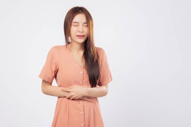 Karın ağrısı ve karın ağrısı, stüdyo beyaz arka planında izole edilmiş periyot kramplarına tepki olarak karnını sıkıca tutan bir kadının duruşunu yansıtıyor.