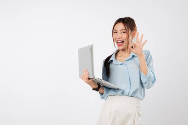 Laptop hazır, heyecanlı genç Asyalı kadın el hareketleriyle gülümsüyor, yakınlarda taşınabilir bir dizüstü bilgisayar pozitif çalışma ruh halini ve anlaşmayı yansıtıyor. izole stüdyo beyaz arkaplan