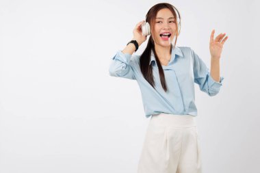 Müzik, genç Asyalı bir kadının kulaklıklara dokunup huzurlu yaşam tarzının bir parçası olarak müzik dinlemesinin keyfini çıkaran mutlu bir gülümseme getiriyor. İnsanlar stüdyonun beyaz geçmişini izole ettiler