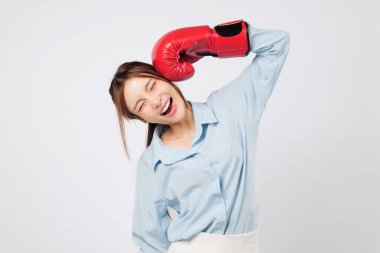 Asyalı genç bir kadının kafasında eldivenlerle güldüğü eğlenceli bir an. Elleri tezahürat, spor salonu enerjisi ve pozitif boks tutumuyla büyümüş. izole stüdyo beyaz arkaplan
