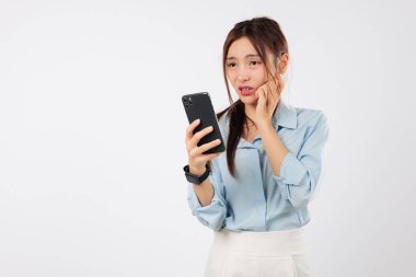 Şok Asyalı kadın üzgün görünüyor. Sürpriz mesaj. Genç Asyalı kadın kötü haberleri görüp telefonunu kullanırken şok oluyor.