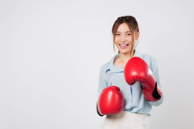 Gülümseyen Asyalı genç bir kadın tarafından gösterilen boks enerjisi ve iş gücü. Gardiyan pozisyonunda hazır, kırmızı boks eldiveniyle güçlü yaşam tarzını birleştiriyor. izole stüdyo beyaz arkaplan