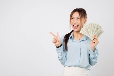 Güzel Asyalı kadın uzayı gösterirken elinde mutlu bir şekilde para tutuyor. Dolar para hayranı gururla sergileniyor. Finansal büyümede başarı ve serveti temsil ediyor. izole stüdyo beyaz arkaplan