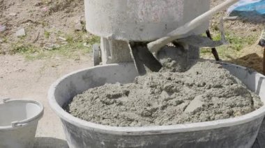 Gri harç ve kumu harmanlayan çimento karıştırıcının yakın çekimi, dayanıklı bir karışım için malzemeleri karıştırırken görülen bıçaklar..